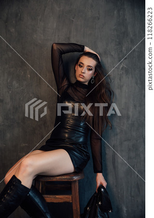 Beautiful fashionable slim woman in black leather dress Beautiful fashionable slim woman in black leather dress 118266223