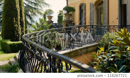 A French Provincial balustrade with elegant curves and intricate wrought iron detailing graces a quaint estate. 118267721