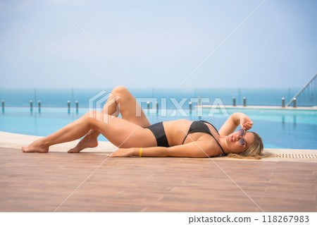 Portrait of beautiful woman in swimwear relaxing in swimming pool in resort 118267983