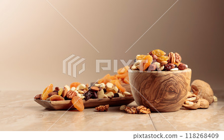 Dried fruits and nuts on a beige ceramic table. Dried fruits and nuts on a beige ceramic table. 118268409