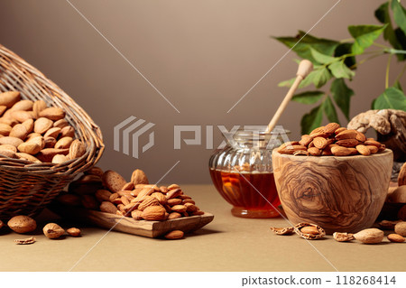 Almond nuts and honey on a brown background. Almond nuts and honey on a brown background. 118268414