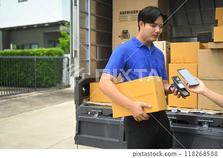 Woman making contactless payment with phone and receiving parcel box from delivery man Woman making contactless payment with phone and receiving parcel box from delivery man 118268588