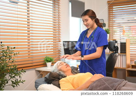 Practitioner with a patient in therapy session touching meridian points on the body, alternative therapy treatment and Reiki technique 118268609