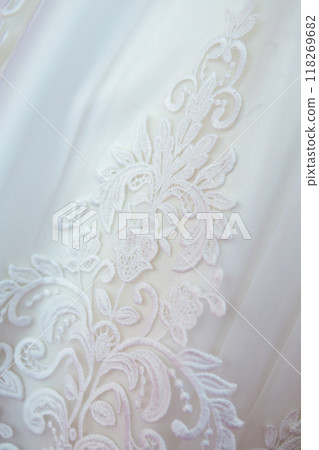 Delicate White Lace Embroidery on a Soft Fabric Background During a Garment Fitting. Delicate White Lace Embroidery on a Soft Fabric Background During a Garment Fitting. 118269682