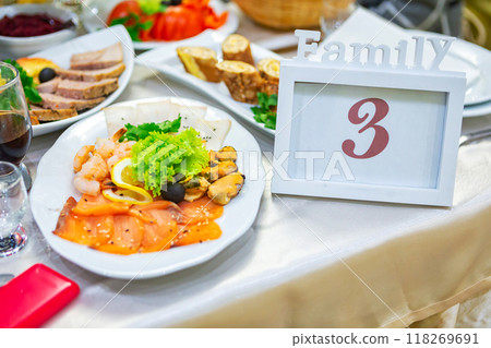 Family Table Setup With Seafood Platter and Elegant Decor at a Celebration Gathering. 118269691