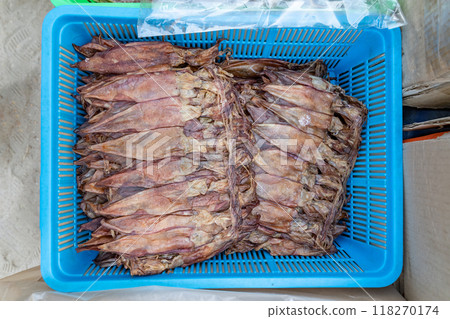 a lot of brown squids that have been placed in a plastic bag to dry in the sun. It is not uncommon for people to dry seafood in this way. 118270174