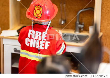 Little boy playing as fireman police occupation in education concept by wearing fire chief uniform with red helmet. 118270473