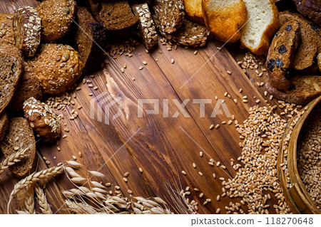Assortment of baked bread on wooden table background Assortment of baked bread on wooden table background 118270648