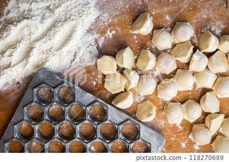 homemade dumplings on a table with flour and a dumplings shape on a wooden table homemade dumplings on a table with flour and a dumplings shape on a wooden table 118270689