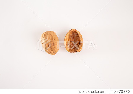 half of a walnut on a white background, one intact outer shell and one hollow inner shell with meat removed. Ideal for themes of food, nutrition, natural textures, or visual metaphors. 118270870