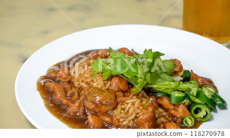 Chicken gravy over rice is a hearty and flavorful dish that combines tender chunks of chicken with a rich and savory gravy, served over a bed of fluffy white rice 118270978