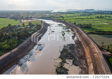 Construction dredges up for a canal and dam, to prevent a flood in the rainy season. Date on 14 May 2021 at Uthai Thani province, Thailand. 118271026