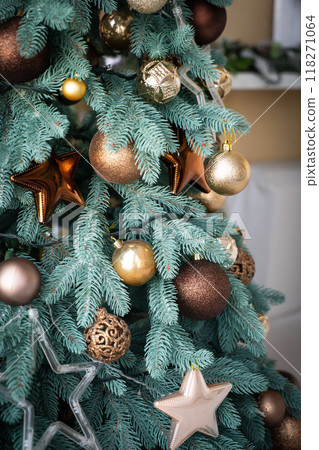 Close up of golden balls on christmas tree. Bokeh garlands in the background. New Year concept. 118271064
