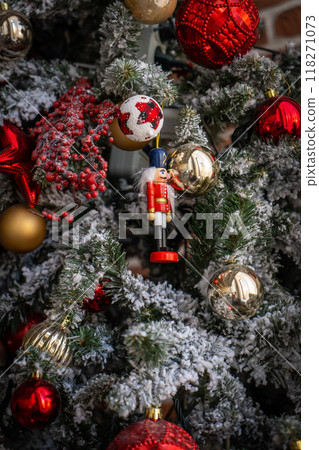 Close up of golden and red balls on christmas tree. Bokeh garlands in the background. New Year concept. 118271073
