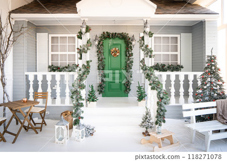 Christmas morning. porch a small house with a decorated door with a Christmas wreath. Winter fairy tale. 118271078