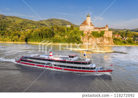 Panorama of Wachau Valley with castle Schonbuhel above the Danube River against tourist boat in Lower Austria, Austria. 118272092