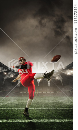 Poster. Player kicks football with forceful swing, mid-action, with stadium lights casting epic glow across field. 3D render of stadium. 118272364