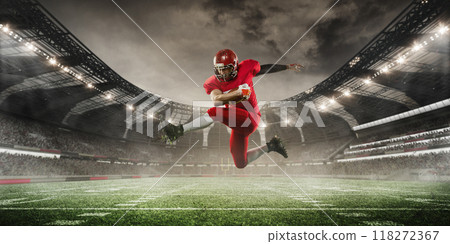 Football player in red uniform is caught mid-air as he leaps high, holding ball tightly, with stadium in background. 3D render of stadium. 118272367