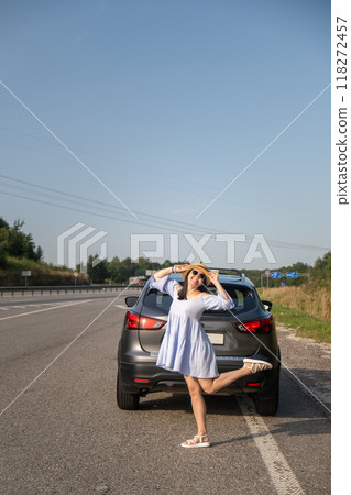 Cheerful Woman Posing by SUV on Sunny Day 118272457