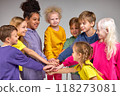 Diverse happy group of kids putting hands together, having fun, studying or playing game 118273081