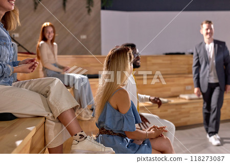 Side view focus on woman sitting on lecture hall listening to speaker man 118273087