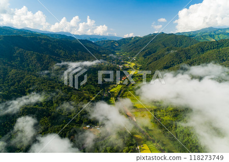 Aerial view drone shot of flowing fog waves on mountain tropical rainforest,Bird eye view image over the clouds Amazing nature background with clouds and mountain peaks Aerial view drone shot of flowing fog waves on mountain tropical rainforest,Bird eye view image over the clouds Amazing nature background with clouds and mountain peaks 118273749