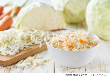 fermented white cabbage with carrot in a white bowl on the table. 118274525