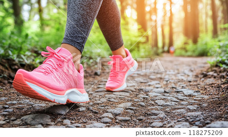 Woman walking along a forest path 118275209