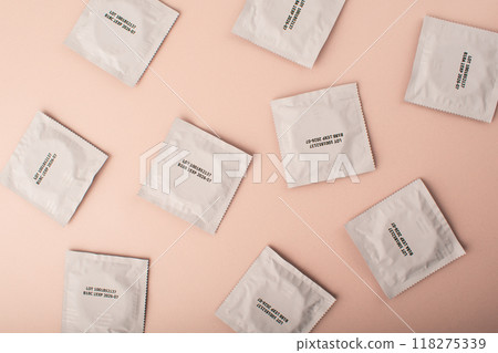 Condoms background pink. Pattern from mens contraception. Sexually transmitted diseases infections protection. Concept of birth control. Safe sex. STD. View from above. High quality photo 118275339
