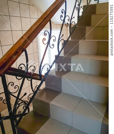 View of the staircase with vintage wrought iron railings and ceramic tile steps, vertical View of the staircase with vintage wrought iron railings and ceramic tile steps, vertical 118275891