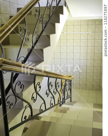 Close-up view of the staircase with vintage wrought iron railings and ceramic tile steps, vertical Close-up view of the staircase with vintage wrought iron railings and ceramic tile steps, vertical 118275897