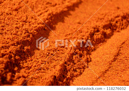Abstract terracotta striped background of scattered paprika seasoning 118276032
