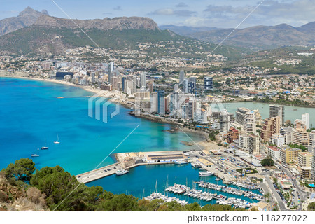 Breathtaking Panoramic View of Calpe's Turquoise Bay from Majestic Cliffside Overlooking Iconic Penon de Ifach Rock Formation. Stunning Costa Blanca Seascape: Calpe's Golden Beaches and Azure Waters Breathtaking Panoramic View of Calpe's Turquoise Bay from Majestic Cliffside Overlooking Iconic Penon de Ifach Rock Formation. Stunning Costa Blanca Seascape: Calpe's Golden Beaches and Azure Waters 118277022