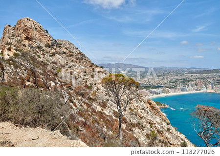 Breathtaking view from the cliff overlooking the stunning Calpe Bay in Spain with crystal-clear waters, sandy beaches, and majestic rock formations under a vibrant blue sky. Panoramic seascape of the Breathtaking view from the cliff overlooking the stunning Calpe Bay in Spain with crystal-clear waters, sandy beaches, and majestic rock formations under a vibrant blue sky. Panoramic seascape of the 118277026