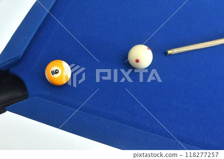 cue stick pointing on white billiard ball ready for shooting nine ball to hole on blue pool table 118277257