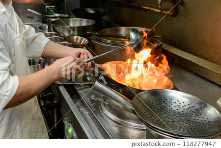 Chinese food cooking scene, a wok with flames Chinese food cooking scene, a wok with flames 118277947