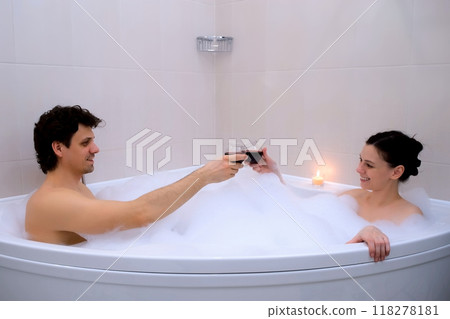 Couple in love enjoying romantic wellness weekend in bathroom drinking wine. Couple in love enjoying romantic wellness weekend in bathroom drinking wine. 118278181