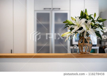 白色廚房的櫃檯上有一瓶白色百合。 118278438