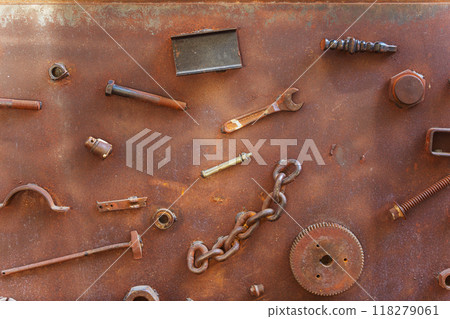 A collection of rusty metal components is resting on a rusty surface 118279061