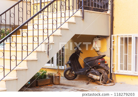 an old bike parked under the stairs at the outdoor house 118279203