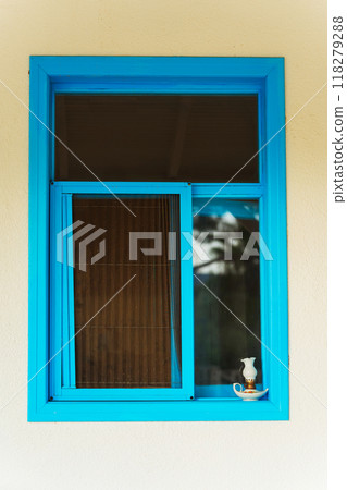 A beautifully designed blue window featuring a lamp on the window sill A beautifully designed blue window featuring a lamp on the window sill 118279288