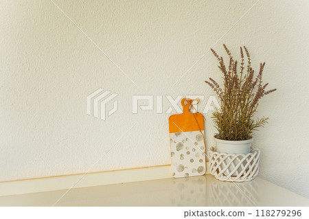 A potted plant is placed on a table right next to a cutting board 118279296