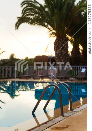 A beautiful swimming pool featuring a palm tree in the background A beautiful swimming pool featuring a palm tree in the background 118279338