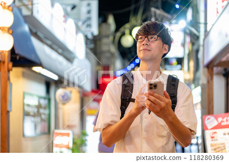 A man looking at his smartphone in the city at night A man looking at his smartphone in the city at night 118280369