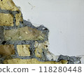 Exposed brick wall with cracked plaster detail 118280448