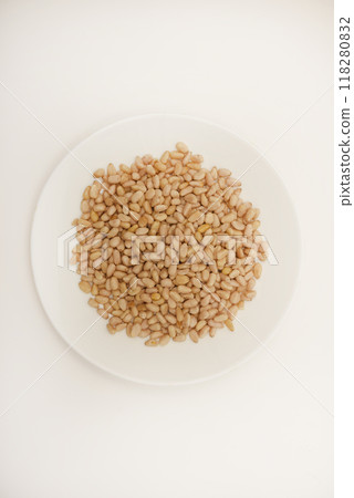 Pine nuts on a white plate. Hazelnuts. Pine nuts on a white plate. Hazelnuts. 118280832