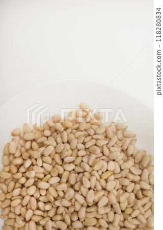Pine nuts on a white plate. Hazelnuts. Pine nuts on a white plate. Hazelnuts. 118280834