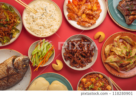 Assorted traditional chinese dishes top view on red background: kung pal chicken, sweet and sour pork, noodles, dumplings, mapo tofu, fish, rice, fortune cookies Assorted traditional chinese dishes top view on red background: kung pal chicken, sweet and sour pork, noodles, dumplings, mapo tofu, fish, rice, fortune cookies 118280901