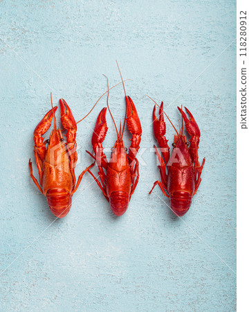 Three whole cooked crawfish lying on blue background top view 118280912
