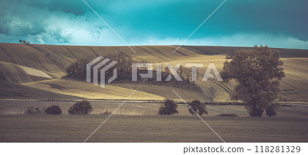 Rolling hills and lush fields define the agricultural landscape of Moravian Tuscany, showcasing vibrant colors under a dramatic sky, highlighting the natural beauty of Czechia's rural charm. Rolling hills and lush fields define the agricultural landscape of Moravian Tuscany, showcasing vibrant colors under a dramatic sky, highlighting the natural beauty of Czechia's rural charm. 118281329